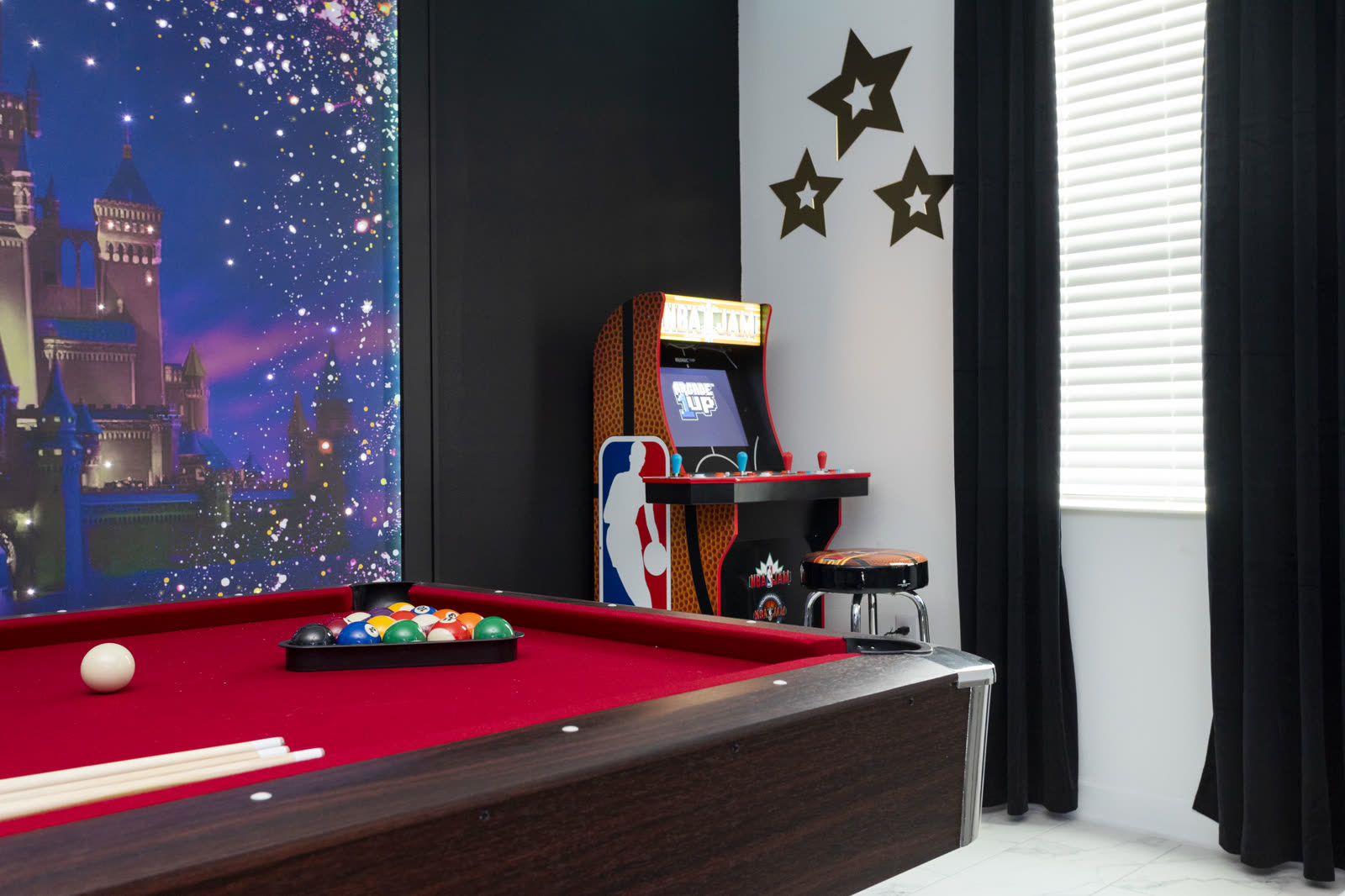 Game room pool table, castle mural, and arcade cabinet at The Disney Villa