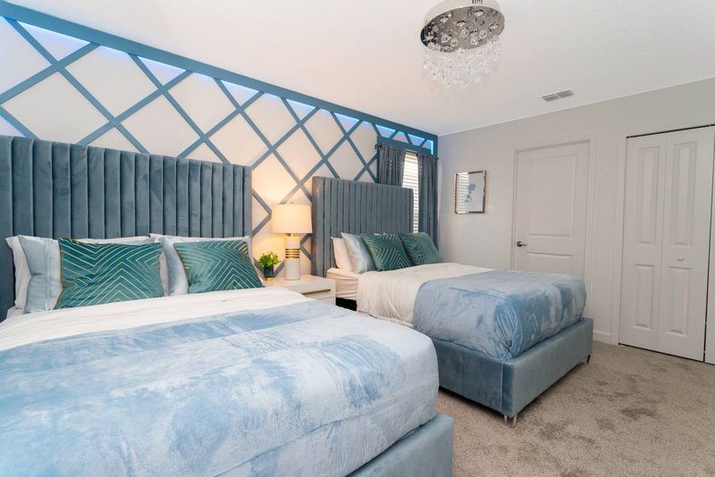 Double room with two double beds and teal lattice accent wall