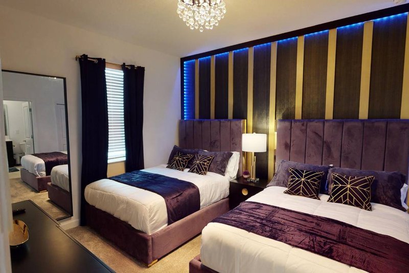 Double room with two double beds and gold striped accent wall