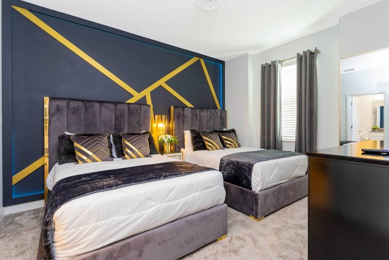 Double room with two double beds and navy gold geometric accent wall
