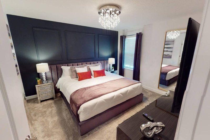 Master suite with king bed and navy accent wall