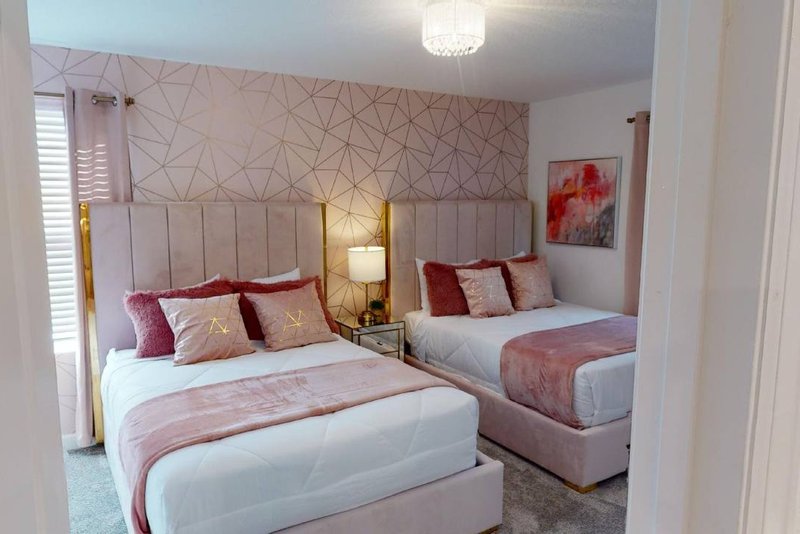 The Pink room with two double beds and blush geometric wallpaper