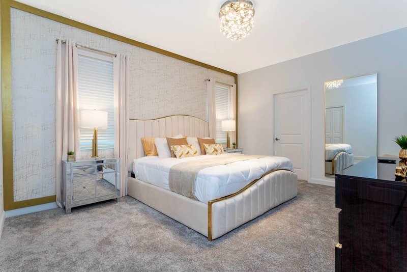 Second master suite with king bed and gold trimmed headboard
